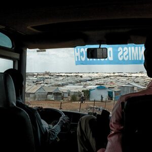 Men driving into refugee camp