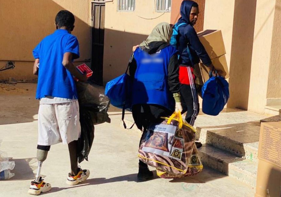 Libya consultant helping migrants CTG Consultant Amira carrying bags