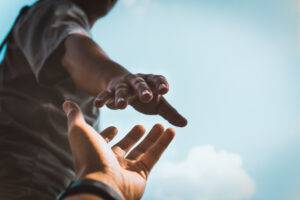 Hands reaching out to help each other in mental health wellbeing